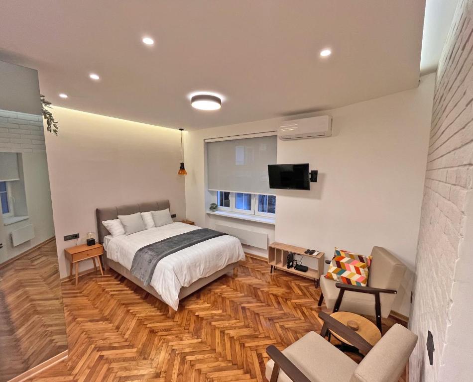 1 dormitorio con 1 cama y TV en la pared en Terazije Center Apartments, en Belgrado