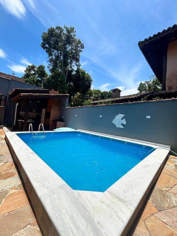 a swimming pool with blue water in a backyard at Casa com piscina em Barra do Una in São Sebastião