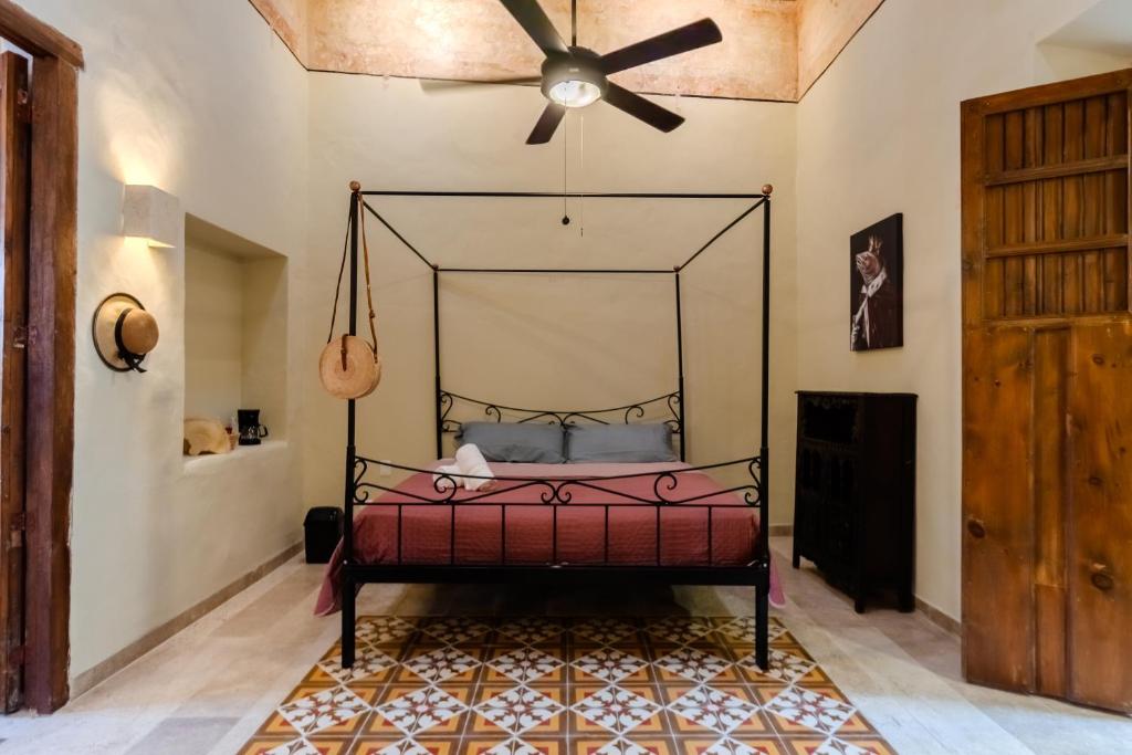 sypialnia z łóżkiem i wentylatorem sufitowym w obiekcie Meriblau Hotel Boutique w mieście Mérida
