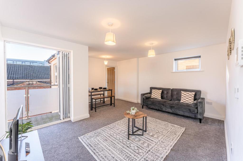 een woonkamer met een bank en een tafel bij Luton flat near town centre for Relocators, Tourists, Families in Luton