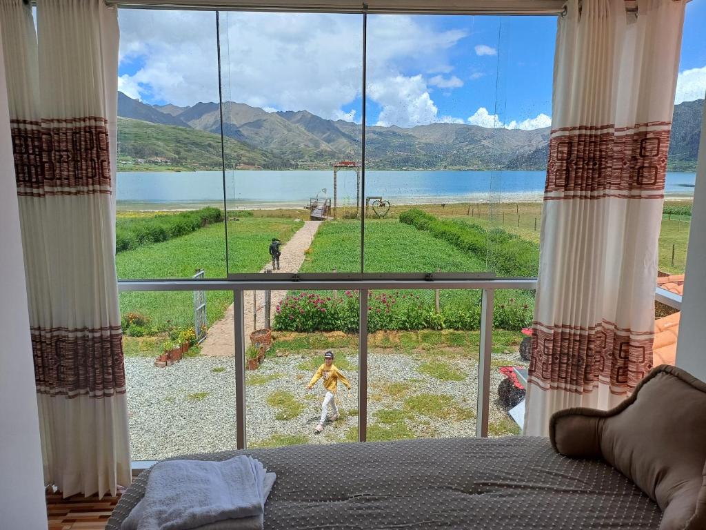 Dormitorio con ventana grande con vistas al lago en Ayllu Piuray en Chincheros