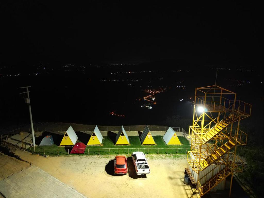 eine Gruppe von Zelten und Autos auf einem Parkplatz nachts in der Unterkunft A Chave da Montanha 
