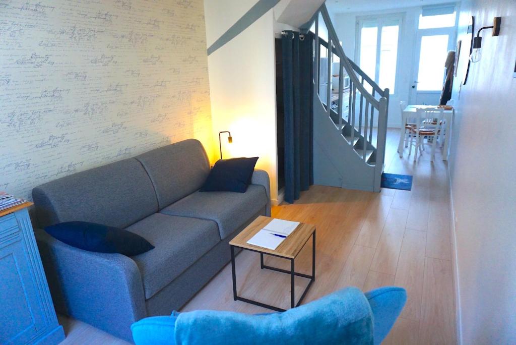 ein Wohnzimmer mit einem Sofa und einem Tisch in der Unterkunft Les Beaux Jours, Tours, le Duplex in Tours