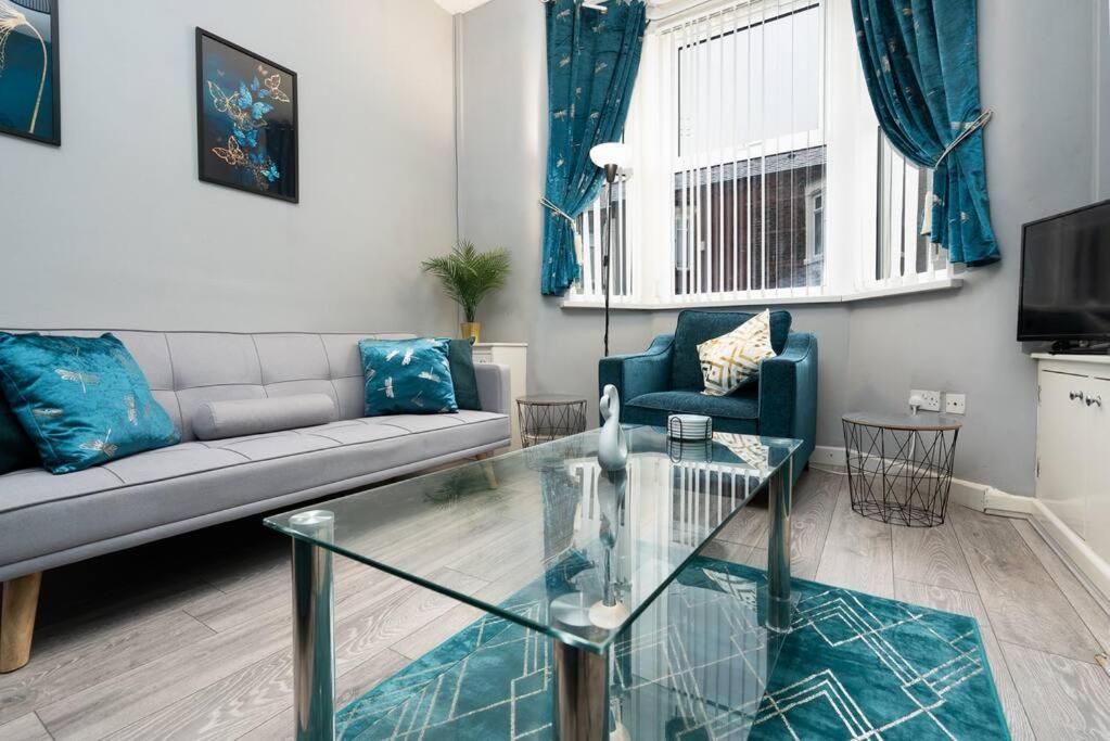 a living room with a couch and a glass table at City Links-3Bdrm terraced House-Parking-Antonio st in Liverpool