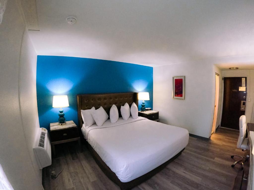a bedroom with a large white bed with a blue headboard at Inn at York in York