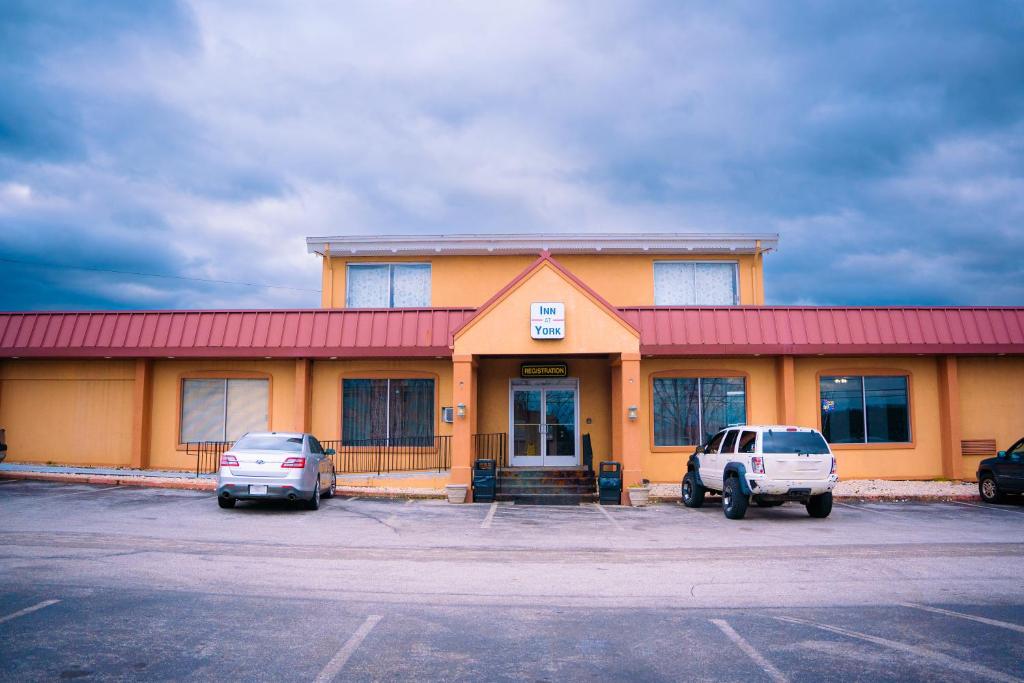 a building with two cars parked in a parking lot at Inn at York in York