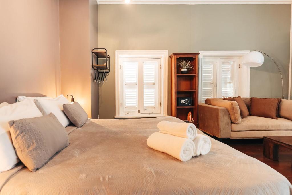 a bedroom with a large bed with two towels on it at Atelier Skalo Boutique Hotel in Willemstad