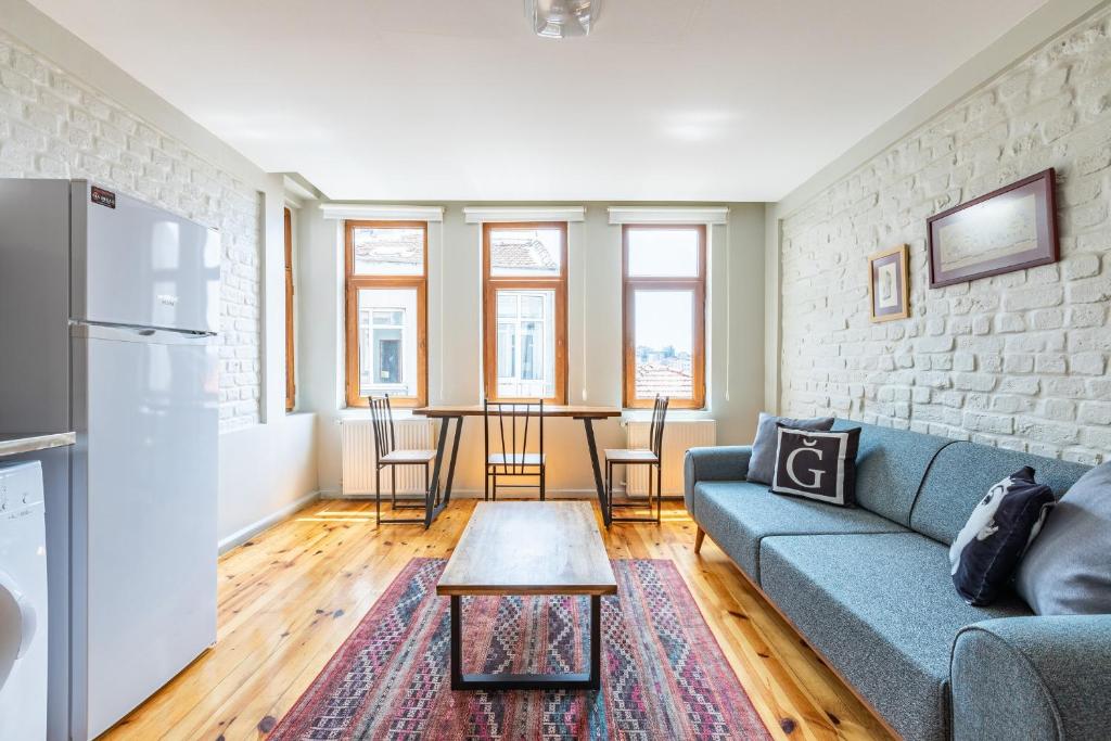 a living room with a blue couch and a brick wall at Pin Exclusive 1 BD Taksim A5 in Istanbul