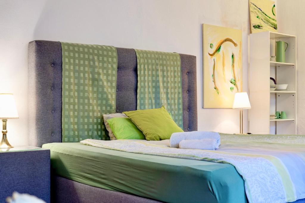 a bedroom with a large bed with a green headboard at Schönes Apartment am Bergpark Wilhelmshöhe in Kassel
