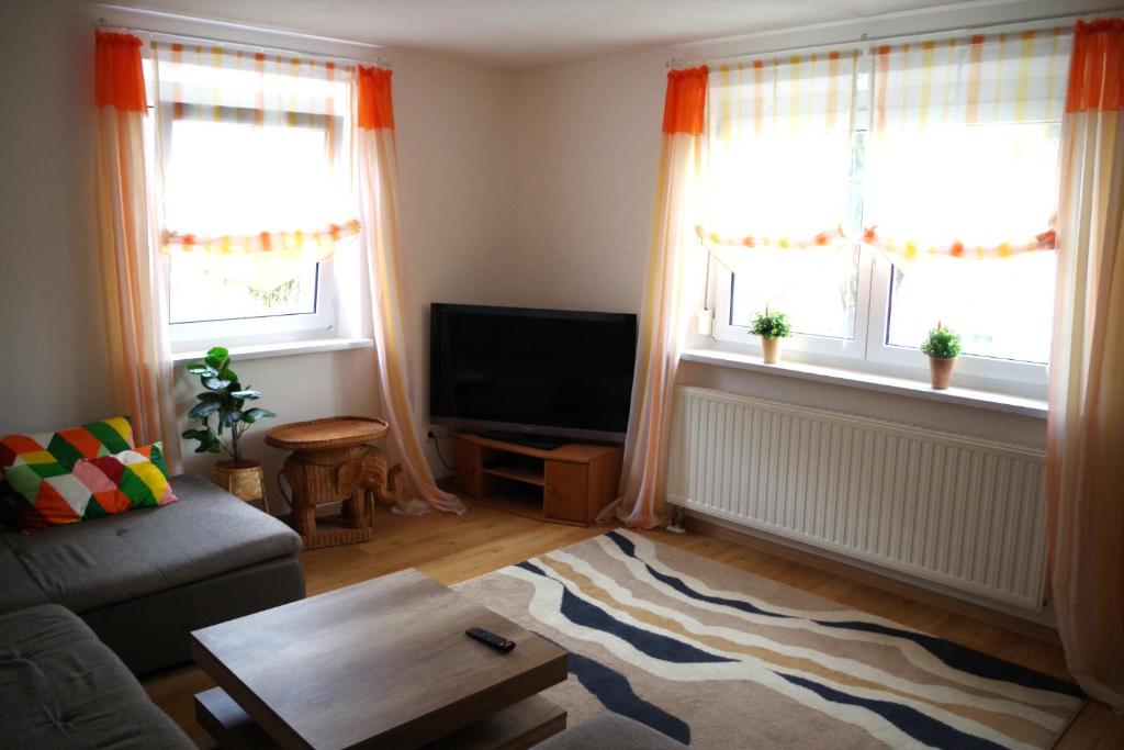 uma sala de estar com um sofá e duas janelas em Ferienwohnung Linde 