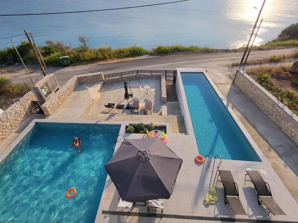 an overhead view of a swimming pool with an umbrella at Ionian Sea Villas in Paleros