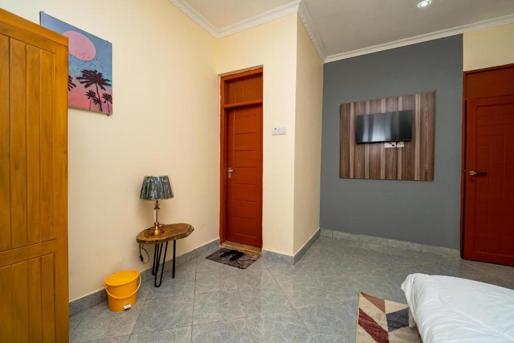 um quarto com uma cama e uma televisão na parede em The Legends Lodge & Apartments em Morogoro