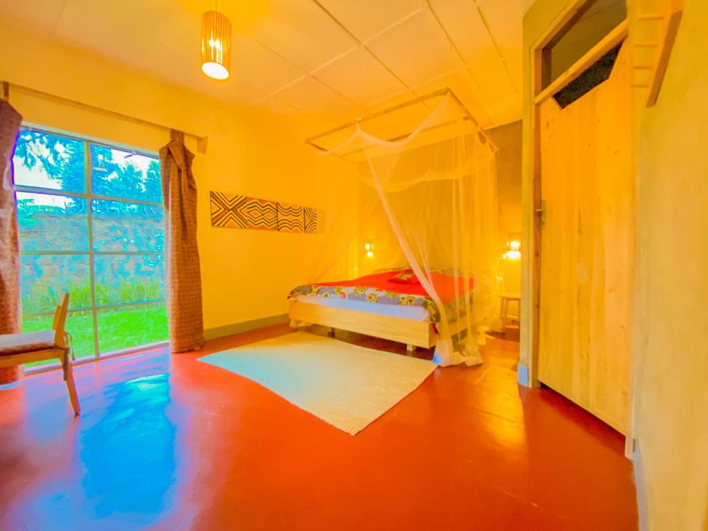 RuhengeriにあるRoom in Guest room - Isange Paradise Resortのベッドルーム(蚊帳付きのベッド付)