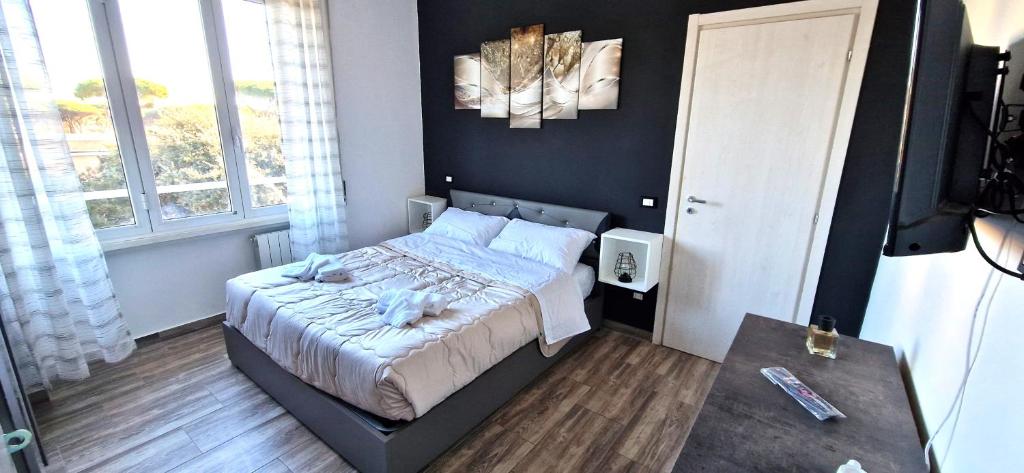 um pequeno quarto com uma cama e uma mesa em Il centro di Ostia (apartment) em Lido di Ostia