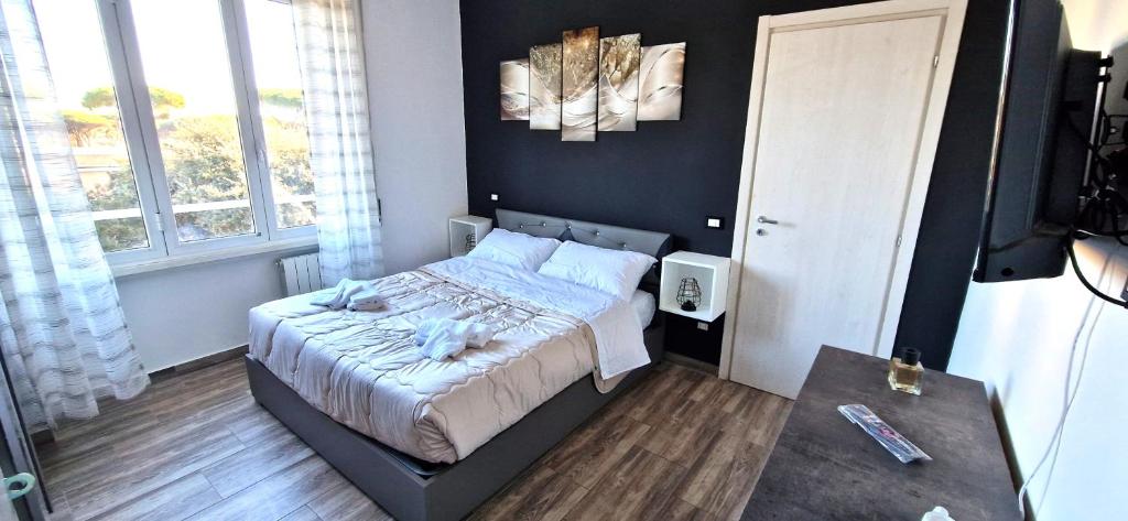 Un pequeño dormitorio con una cama y una mesa. en Il centro di Ostia (apartment), en Lido di Ostia