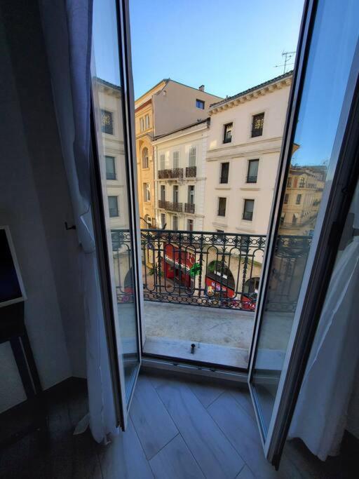 - une vue sur un balcon depuis la fenêtre d'un bâtiment dans l'établissement Appartement Rue d'Antibes, à Cannes