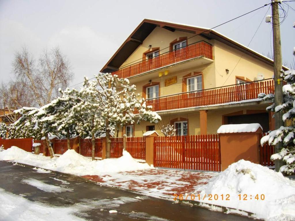 una casa con una valla y nieve delante de ella en AGAWA NOCLEGI, en Tarnów
