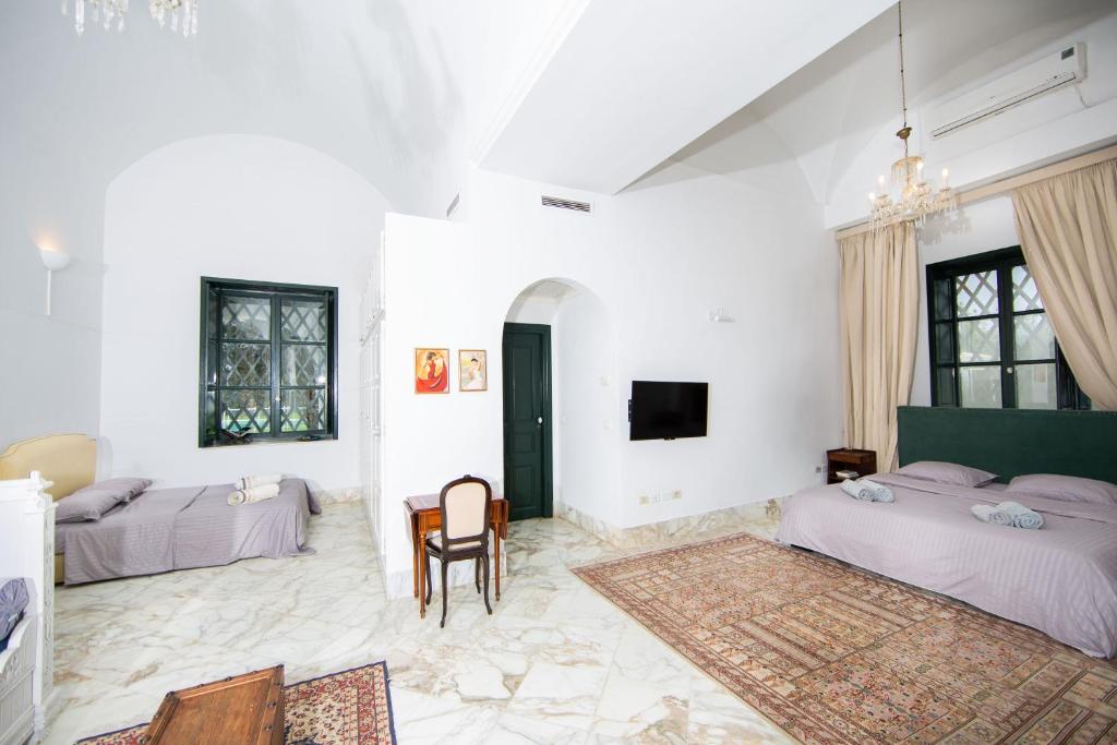 a bedroom with two beds and a table in it at Appartement privé dans une grande maison d'hote in La Marsa