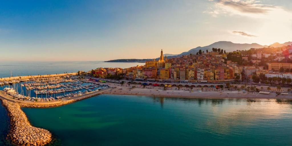 een luchtzicht op een stad met een strand bij Confortable 2 pièces entre Menton et Monaco avec parking privé in Roquebrune-Cap-Martin