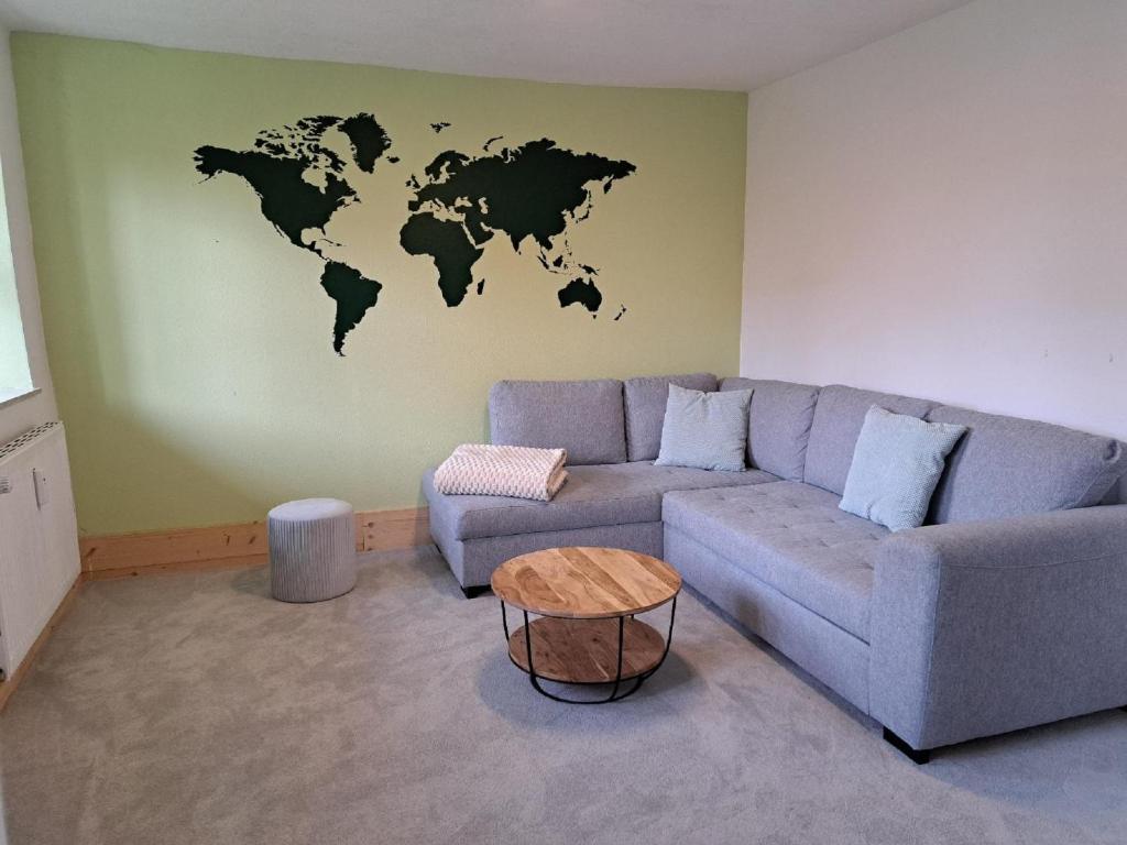 una sala de estar con sofá y un mapa mundial en la pared en Haus Gerda - Ferienwohnung 1, en Arnbruck