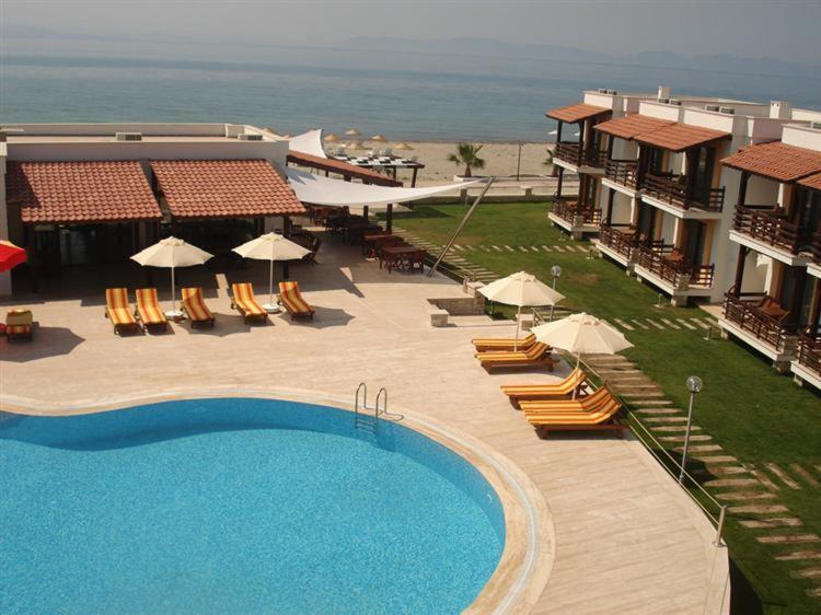 a resort with a swimming pool and chairs and umbrellas at Hotel Silvanus in Oren