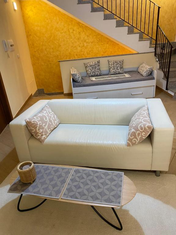 ein Wohnzimmer mit einer weißen Couch und einer Treppe in der Unterkunft Casa Marconi duplex avec terrasse in Aragona