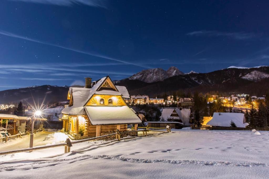 ein Haus mit Schnee in der Nacht in der Unterkunft Domek VIP PIETIA in Zakopane