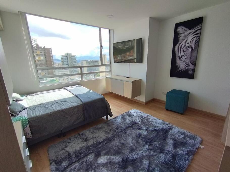 a bedroom with a bed and a large window at Torre Acqua - Centro turístico, Vistas Panorámicas in Bogotá