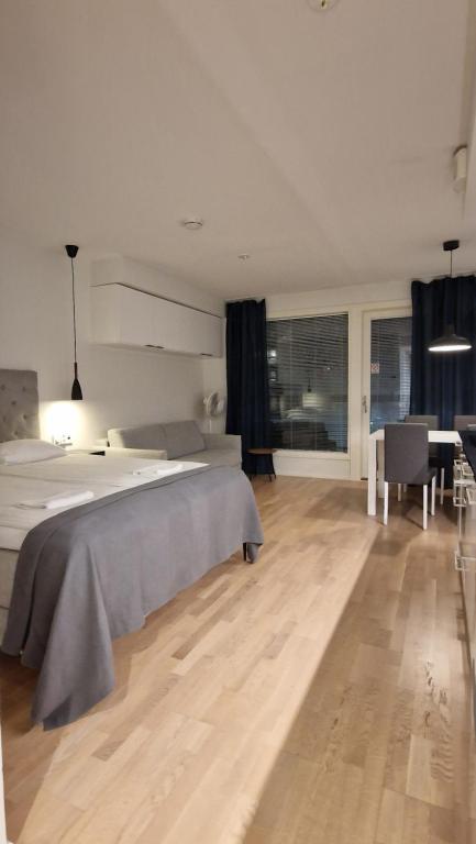a bedroom with a bed and a table and a desk at Silent apartment with balcony in Turku