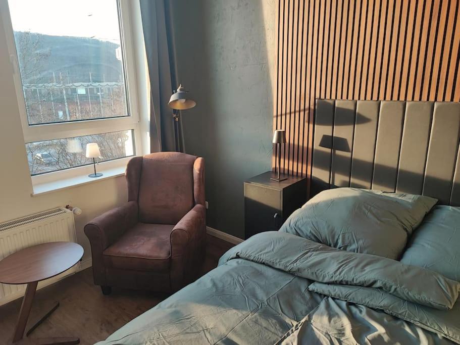 1 dormitorio con 1 cama, 1 silla y 1 ventana en Modernes Juwel in Hagen City, en Hagen