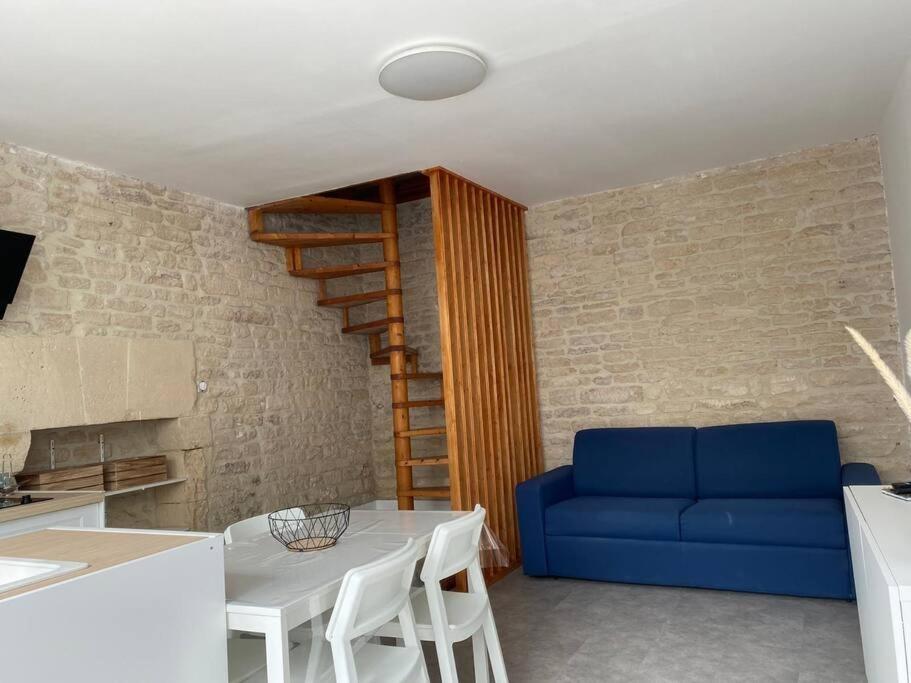 ein Wohnzimmer mit einem blauen Sofa und einem Tisch in der Unterkunft Gîte de La baleine in Luc-sur-Mer