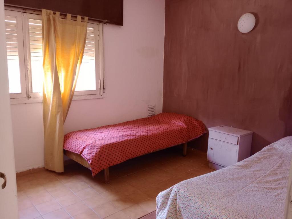 a small bedroom with a bed and a window at SOL Y LAGO in Villa Carlos Paz