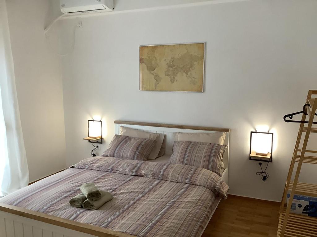un ours en peluche posé sur un lit avec deux lumières dans l'établissement NeMapartment, à Athènes