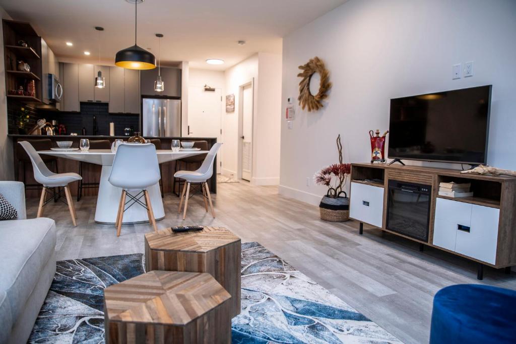 a living room with a table and a tv at Revelstoke Marvel - Two Bedroom with Hot Tub in Revelstoke