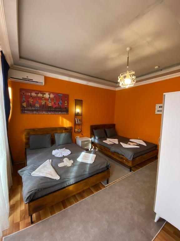 two beds in a room with orange walls at Taksim Pandora hotel in Istanbul
