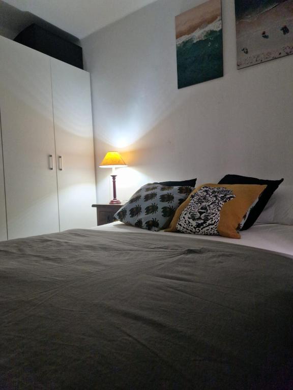 a bedroom with a bed with pillows and a lamp at ALCOY-DENIA in Denia