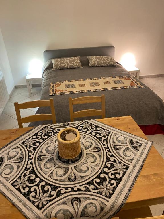 een slaapkamer met een bed en een tafel met een tapijt bij Casa Marconi 3, centrale, parking gratuit en rue. in Aragona