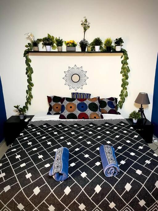 una camera da letto con un letto con sopra delle pantofole blu di Chez Diogoye a Dakar