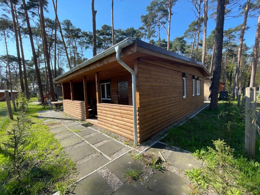 een kleine houten hut in een bos met bomen bij Domek Dębowy 2 in Lubniewice