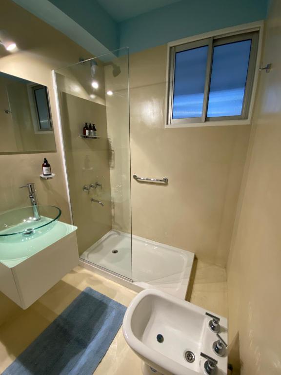 ein Bad mit einer Glasdusche und einem Waschbecken in der Unterkunft Restaurado a nuevo en el Corazón de la Ciudad in Neuquén
