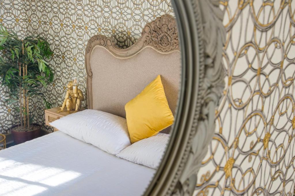 Spiegelreflexion eines Bettes mit einem gelben Kissen in der Unterkunft Stunnning 4 Bed House Hot Tub Sky Tv Pool Table in London