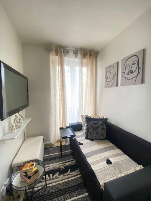 un salon avec un canapé et une télévision à écran plat dans l'établissement APP Cozy en plein coeur de Paris, à Paris
