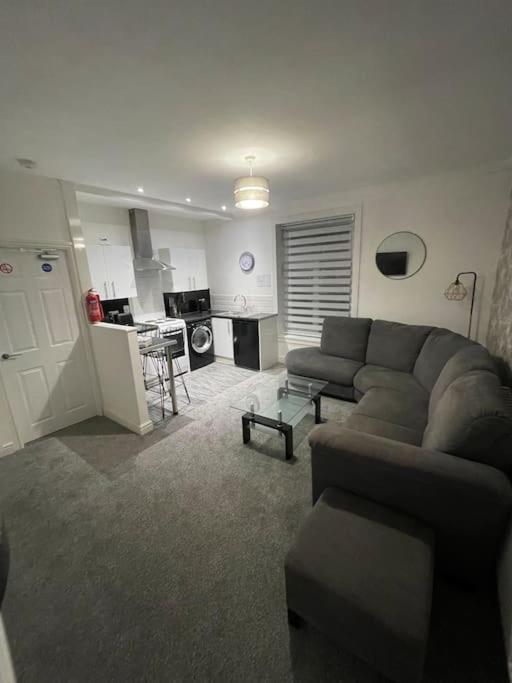 a living room with a couch and a kitchen at 212a bell lane in Bury