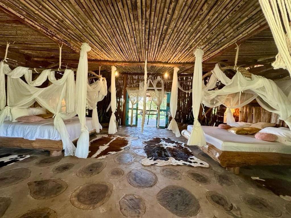 Villa Flor的住宿－wellgaya ecovillas，一间卧室配有两张带吊床的床。