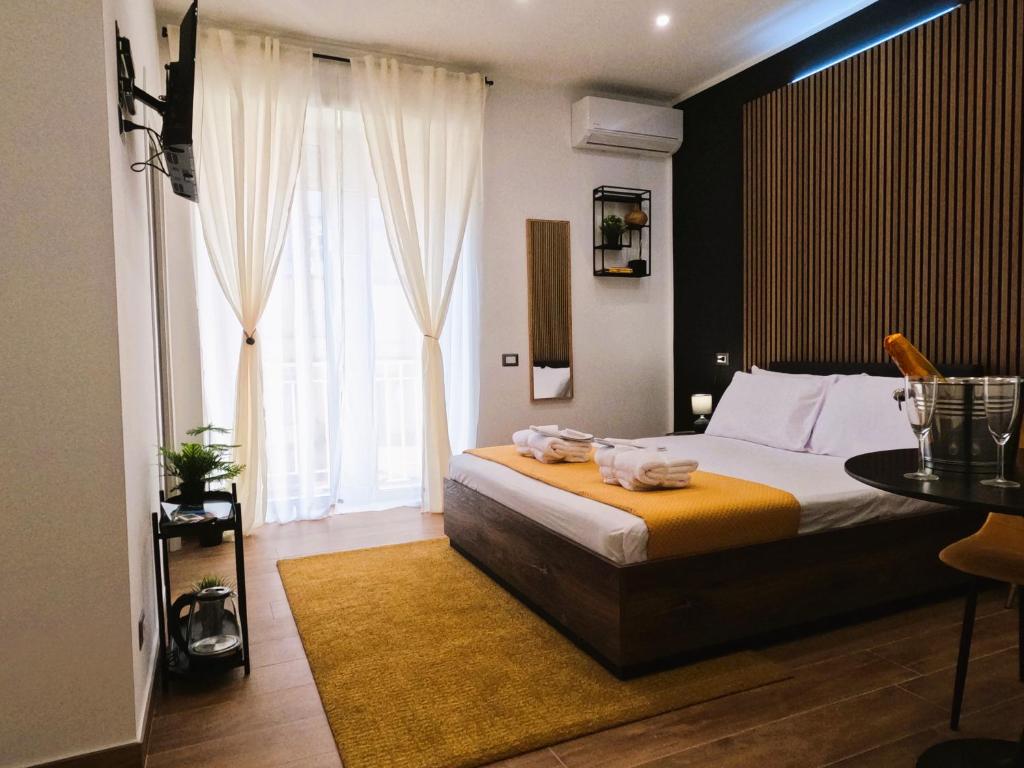 a bedroom with a bed and a table and a window at BlackWoody Contemporary Rooms - Napoli Centro Storico in Naples