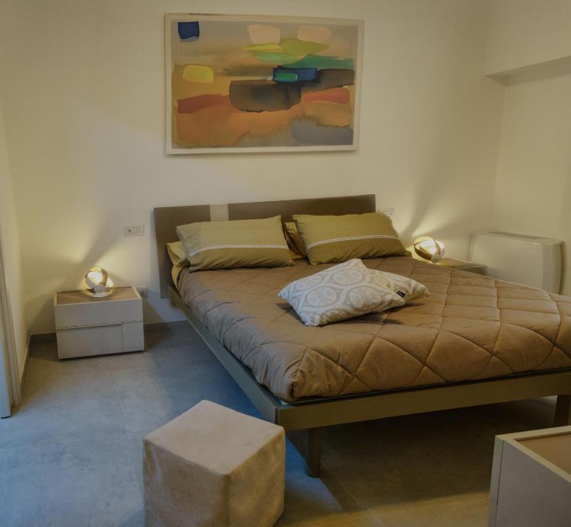1 dormitorio con 1 cama y una pintura en la pared en Casadoria34 - Appartamento da 70 mq, en Mola di Bari