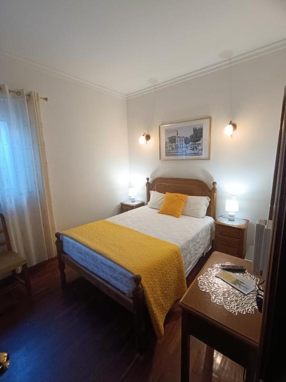 een kleine slaapkamer met een bed en een tafel bij Casa 42 in Monção