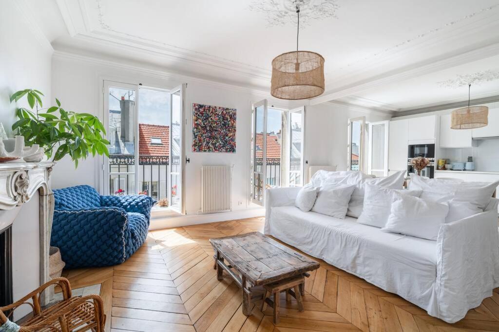 un salon avec un canapé blanc et une table dans l'établissement Charmant appartement, à Neuilly-sur-Seine