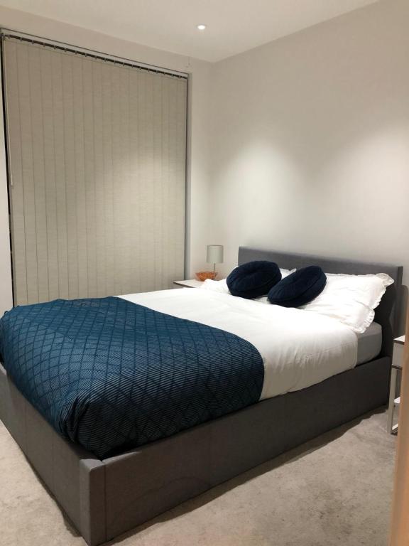 sypialnia z dużym łóżkiem z niebieską pościelą i poduszkami w obiekcie Double Room w Londynie