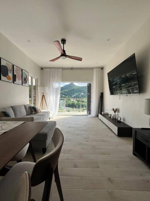 a living room with a couch and a ceiling fan at Modern condo close to Rodney Bay and Airport in Gros Islet